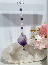 Load image into Gallery viewer, THE MYSTIC AWAKENING" Handcrafted Amethyst Raw Crystal Stone Silver Crystal Energy Enhancer© Hanger Ornament Suncatcher

INSPIRES INTUITION, WISDOM AND SPIRITUALITY

Stunning Raw Amethyst crystal stone beaded with Amethyst and Quartz. Wire wrapped in silver
