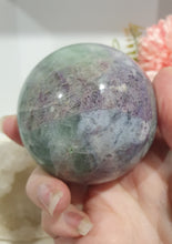 Load image into Gallery viewer, Beautiful Fluorite Sphere Crystal Carving on Silver Stand. Inspires Stability, Grounding and Concentration. Lovely patterns and colouring with inclusions. 

