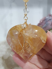 Load image into Gallery viewer, This stunning Ultimate Healer Crystal Energy Enhancer Suncatcher is handcrafted and created with a stunning Golden Healer heart and beaded with golden healer and quartz. Hang in your home or space and feel the ambient energy. Inspires Power and connection. See our other Crystal Suncatchers
