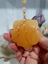 Load image into Gallery viewer, Stunning "ROSE OF SUNSHINE" Handcrafted Orange Calcite Rose Carving gold Crystal Energy Enhancer© Hanger Ornament Suncatcher. hang in your room or space. Inspires Joy, cleansing and love
