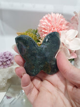 Load image into Gallery viewer, Butterfly Moss Agate Crystal Carving Stone on Stand. Inspires tranquility and grounding.

Beautiful polished Moss Agate Butterfly Crystal Carving on plastic stand
