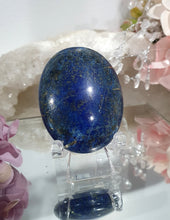 Load image into Gallery viewer, Lapis Lazuli Crystal Palm Stone palm stone on plastic stand. 

INSPIRES HARMONY, WISDOM &amp; PSYCHIC PROTECTION

Lovely Lapis Lazuli Crystal Palm stone with pyrite inclusions on plastic stand. So pretty.  


