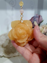 Load image into Gallery viewer, Stunning "ROSE OF SUNSHINE" Handcrafted Orange Calcite Rose Carving gold Crystal Energy Enhancer© Hanger Ornament Suncatcher. hang in your room or space. Inspires Joy, cleansing and love
