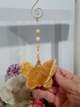 Load image into Gallery viewer, Beautiful polished Butterfly of Joy and manifestation Crystal Energy Enhancer / Sun catcher / Hanger / Ornament. Orange Calcite Butterfly Crystal Carving beaded with golden healer and moonstone.   

