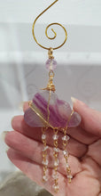 Load image into Gallery viewer, Lovely "EVERY CLOUD HAS A SILVER LINING" Fluorite Cloud gold wired Crystal Energy Enhancer© Hanger Ornament Suncatcher.

From Darkness comes Light. 

TRANSFORMATION / INTUITION / SPIRITUALITY

Beautiful Fluorite Cloud Crystal Carving beaded with Fluorite &amp; Quartz.  wired in Gold
