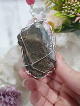 Load image into Gallery viewer, ENCHANTED AURA - Handcrafted Titanium Aura Quartz Crystal Energy Enhancer© / Hanger / Ornament / Suncatcher 

inspires EMPOWERMENT | COMPASSION | MAGICK

Gorgeous Titanium Aura Quartz crystal beaded with Rhodochrosite, Amethyst and Rose Quartz. Wire wrapped in silver

Genuine Crystals. no plastic or glass. Ensuring energy flow throughout the enhancer. Crystal Suncatchers
