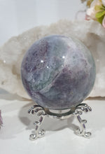 Load image into Gallery viewer, Beautiful Fluorite Sphere Crystal Carving on Silver Stand. Inspires Stability, Grounding and Concentration. Lovely patterns and colouring with inclusions. 


