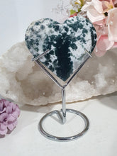 Load image into Gallery viewer, Heart Moss Agate Crystal Carving Stone on stand

INSPIRES GROUNDING AND CONNECTION TO EARTH

Lovely Moss Agate Heart Crystal Carving on silver stand. 
