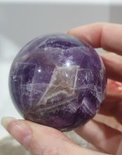 Load image into Gallery viewer, Amethyst Chevron Sphere Crystal Carving Stone on Gold Stand

Inspires INTUITION AND SPIRITUALITY

Lovely Amethyst Crystal Sphere on gold stand.  Gorgeous colouring.  
