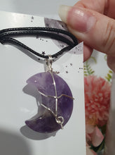 Load image into Gallery viewer, Amethyst Moon Crystal Pendant Wire Wrapped Silver Stone with black cord chain

INSPIRES INTUITION AND SPIRITUALITY

Beautiful Amethyst Moon Crystal Carving Wire Wrapper in Silver non tarnish wire. Accompanied by a black cord necklace
