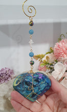 Load image into Gallery viewer, HEART OF THE OCEAN" Handcrafted Titanium Aura Sphalerite Heart Stone Crystal Carving Gold Crystal Energy Enhancer© / Hanger / Ornament / Suncatcher

Inspires PSYCHIC FLOW | LOVE | INTUITION

Gorgeous Titanium Aura Sphalerite heart crystal carving beaded with Aquamarine, Rainbow Hematite &amp; Quartz.  Wire wrapped in gold
