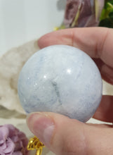 Load image into Gallery viewer, Celestite Sphere Crystal Carving on Gold Stand. Inspires Communication with the Angels
