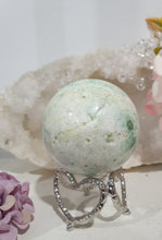 Load image into Gallery viewer, Phoenix Stone Sphere Crystal Carving Stone on Silver Stand

Inspires Compassion

Lovely Phoenix Stone Crystal Sphere Carving Stone on silver stand.  
