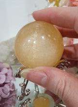 Load image into Gallery viewer, Honey Calcite Sphere Crystal Carving on silver stand

INSPIRES SELF WORTH AND CONFIDENCE

lovely Honey Calcite sphere on ornate silver stand
