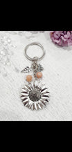 Load image into Gallery viewer, THE SUNFLOWER KEEPER" Metal Sunflower with Sunstone Beads Crystal Keyring.

Choose from Gold of Silver medal colour.

INSPIRES JOY | HOPE | OPTIMISM

Carry a little Sunshine wherever life takes you!

 "The sunflower has long symbolised joy, hope and unwavering optimism. Like the flower that turns towards the sun, it reminds us to keep looking for the light, even through life's difficult seasons".

Gorgeous Metal sunflower Keyring Key ring beaded with AAA sunstone faceted beads.

