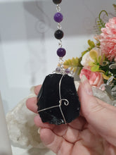 Load image into Gallery viewer, WITCHES AMULET - Handcrafted Obsidian Stone Crystal Energy Enhancer© / Hanger / Ornament / Suncatcher 

INSPIRES PROTECTION AND INTUITION

Gorgeous Obsidian raw crystal stone beaded with Black Obsidian and Amethyst. Wire wrapped in silver

