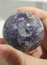 Load image into Gallery viewer, Purple Sphalerite Sphere Crystal Carving on Silver Stand.

Inspires Spirituality &amp; Strength

Stunning Purple Sphalerite Crystal Sphere on Silver Sand. This has a gorgeous quartz vein and pocket of druzy. 
