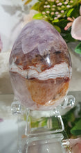 Load image into Gallery viewer, Amethyst Agate Egg Crystal Carving Stone on Stand

Inspires intuition and Emotional Well Being

Beautiful Polished Amethyst Agate Egg Crystal Carving on plastic stand. Has natural divits formations.
