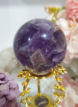 Load image into Gallery viewer, Amethyst Chevron Sphere Crystal Carving Stone on Gold Stand

Inspires INTUITION AND SPIRITUALITY

Lovely Amethyst Crystal Sphere on gold stand.  Gorgeous colouring.  
