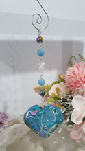Load image into Gallery viewer, HEART OF THE OCEAN" Handcrafted Titanium Aura Sphalerite Heart Crystal Carving Silver Crystal Energy Enhancer© / Hanger / Ornament / Suncatcher

Inspires PSYCHIC FLOW | LOVE | INTUITION

Gorgeous Titanium Aura Sphalerite heart crystal carving stone beaded with Aquamarine, Rainbow Hematite &amp; Quartz.  Wire wrapped in silver
